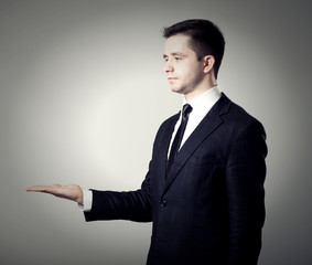 young businessman presenting something on his hand