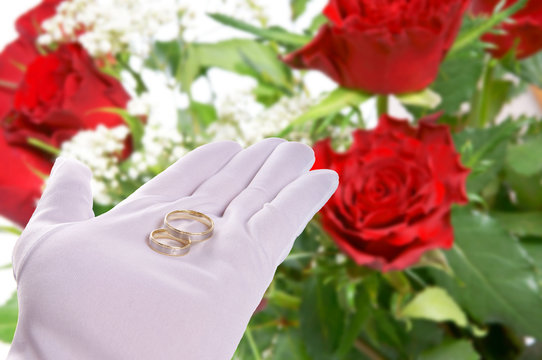 Hand holding Wedding Rings with roses background