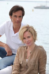 Couple with boat in the background