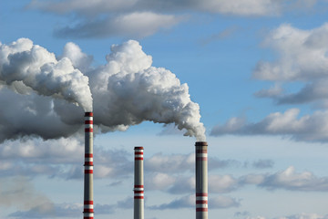three chimney and white smoke polluted sky