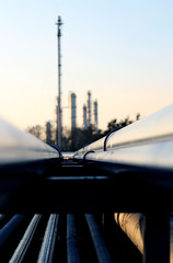 long pipe and silhouette of oil refinery
