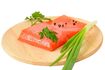 Salmon fillet, green onion and parsley on kitchen board