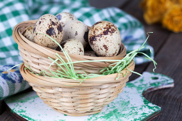Obraz premium Quail Eggs in a basket with straw, Selective Focus