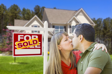Couple in Front of Real Estate Sign and House
