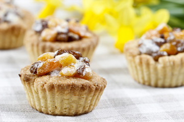 Homemade tarts with dried fruits on checked table cloth
