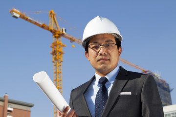 Young architect standing front of a building site