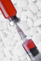 Medical vial and syringe on white pills and tablets background