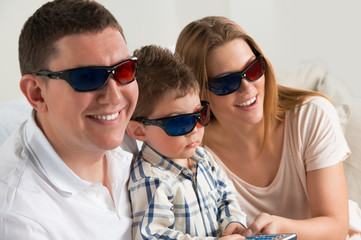 Family laughing while watching television together in the living