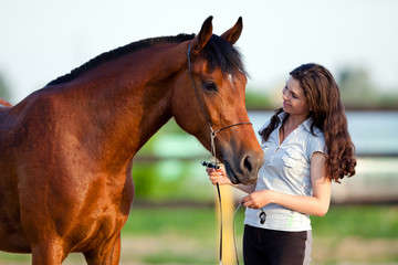 Young girl and bay horse outdoor