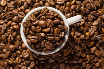 Cup full of black coffee beans