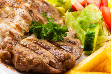 Grilled steak, French fries and vegetables