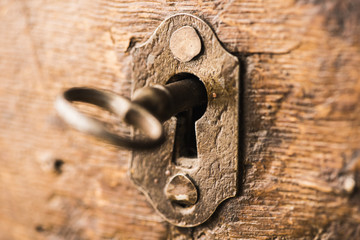 Vintage key in lock of wooden chest
