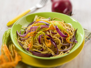 spaghetti with pumpkin flowers and onions, selective focus
