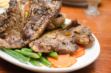 Lamb Chop with carrot slices on a white plate