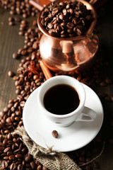 Cup of coffee and pot on wooden background