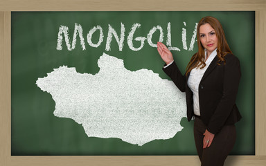 Teacher showing map of mongolia on blackboard