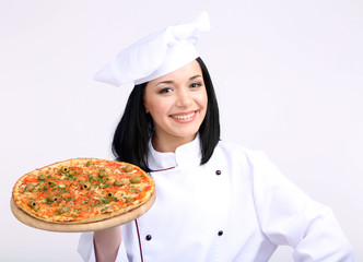 Beautiful girl chief-cooker with pizza isolated on white