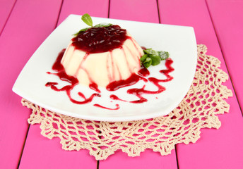 Panna Cotta with raspberry sauce, on color wooden background