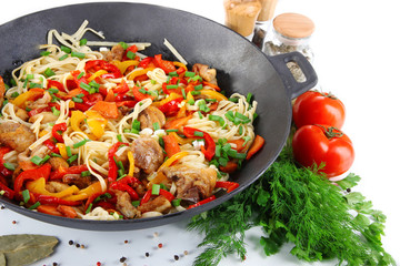 Noodles with vegetables on wok isolated on white