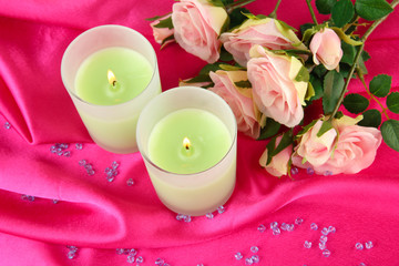 Candle on pink fabric close -up
