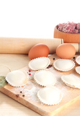 Raw dumplings and ingredients on wooden table, isolated on
