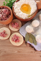 Fototapeta na wymiar Raw dumplings, ingredients and dough, on wooden table