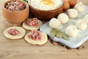 Raw dumplings, ingredients and dough, on wooden table