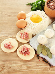 Raw dumplings, ingredients and dough, on wooden table