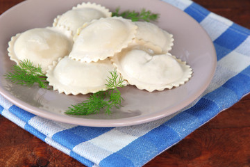 Tasty dumplings on plate, on wooden table