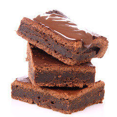 Slices of a brownie on white coverd with chocolate