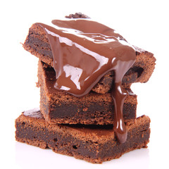 Slices of a brownie on white coverd with chocolate