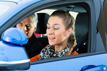 Junge Frau in einem Fahrschulauto