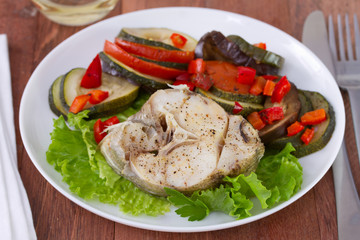 fish with salad and vegetables on the plate