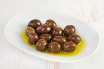 olives with oil on white dish