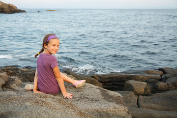 Little girl siting by the sea