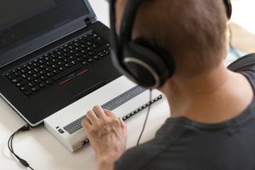Blind person working on computer with braille display and screen - obrazy, fototapety, plakaty