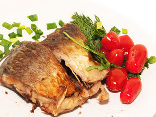 whole fried sunfish over plate with tomatoes