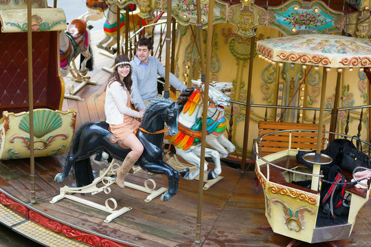Couple having fun on a merry-go-round