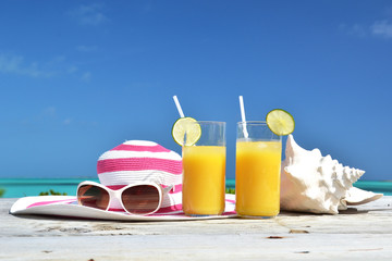 Orange juice, hat, sunglasses and conch