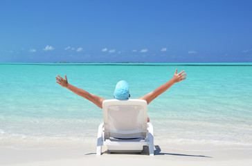 A young man sunbathing on the beach of Exuma, Bahamas