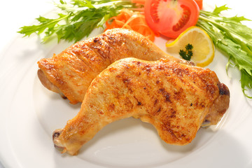 Grilled chicken thigh with vegetables on white plate