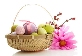 Fototapeta na wymiar Beautiful easter eggs and apricot blossom in basket, isolated
