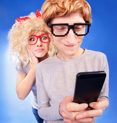 Girl is spying on boyfriend he is using a smart phone