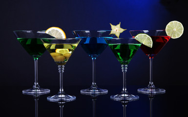 Alcoholic cocktails in martini glasses on dark blue background