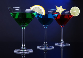 Alcoholic cocktails in martini glasses on dark blue background