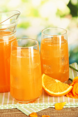 Obraz na płótnie Canvas Glasses and pitcher of orange juice