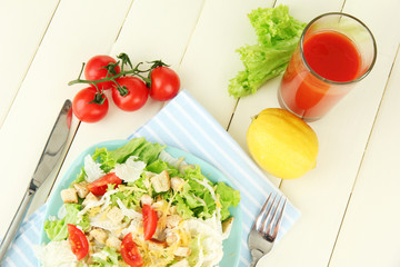 Caesar salad on blue plate, on color wooden background
