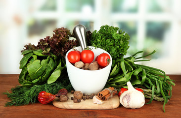 Composition of mortar, spices, tomatoes and  green herbs,