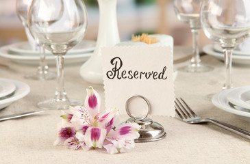 Reserved sign on restaurant table with empty dishes and glasses
