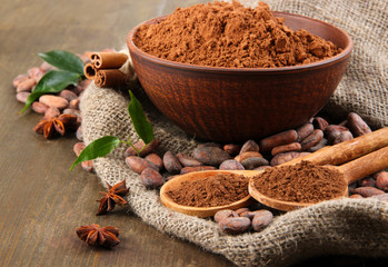Cocoa powder and cocoa beans  on wooden background